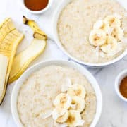 two bowls of steel cut oats topped with banana slices