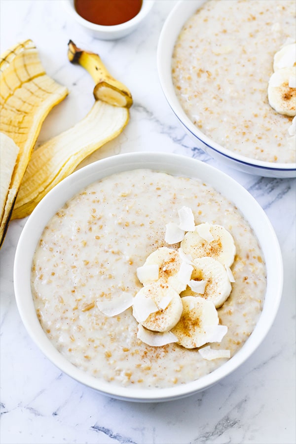 two bowls of banana maple steel cut oats topped with banana slices