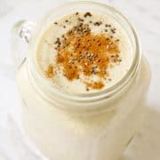 banana chia smoothie in glass jar with cinnamon and chia seeds sprinkled on top