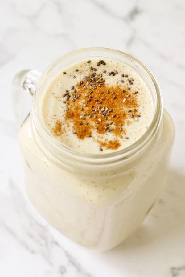 chia banana smoothie in glass jar with cinnamon and chia seeds sprinkled on top