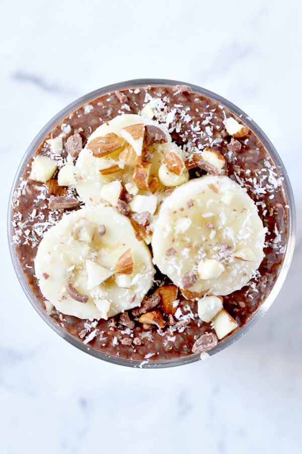 chocolate chia pudding with banana slices, chopped almonds and coconut on top
