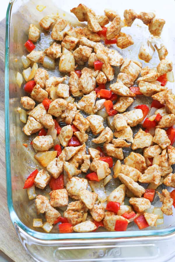 cooked chicken, onion and capsicum on a baking tray