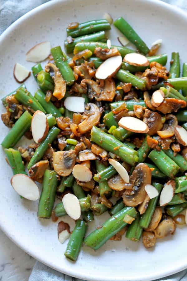 sautéed green beans and mushrooms on a white plate