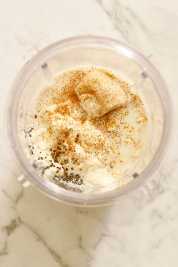 banana oat smoothie ingredients in a blender cup