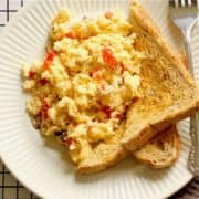 scrambled eggs on toast with text overlay "scrambled eggs with cheese and veggies".