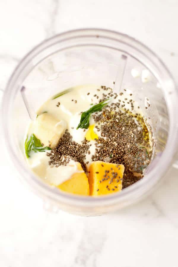 spinach mango smoothie ingredients in a blender cup