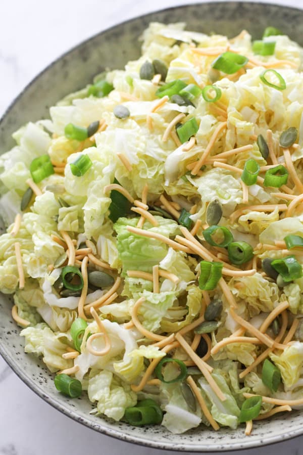 cabbage and crunchy noodle salad in a large grey bowl.
