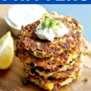 fritters stacked on top of each other with text overlay "zucchini & halloumi fritters".