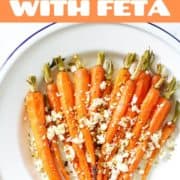 roasted dutch carrots with feta and dukkah on a white plate.