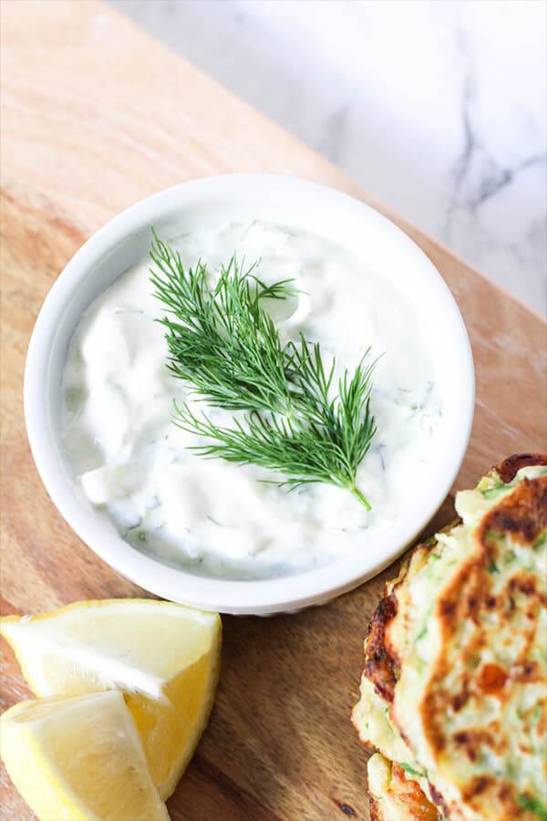 Greek Tzatziki in a white bowl with a sprig of dill on top