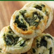spinach and feta pinwheels on a wooden serving board.