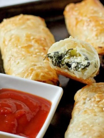 spinach and ricotta rolls on a baking tray.