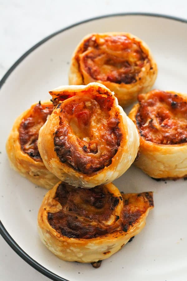 pizza pinwheels on a white plate.