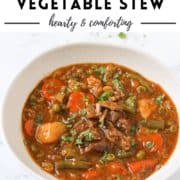 stew in a white bowl with text overlay "beef & vegetable stew".