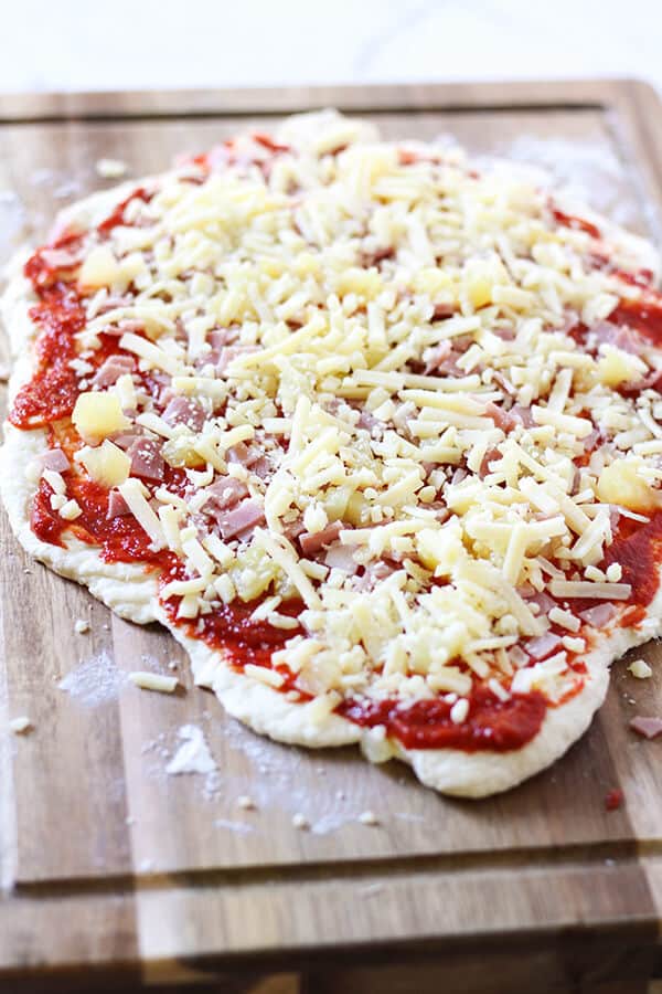 dough topped with ham, cheese, tomato paste and pineapple. 