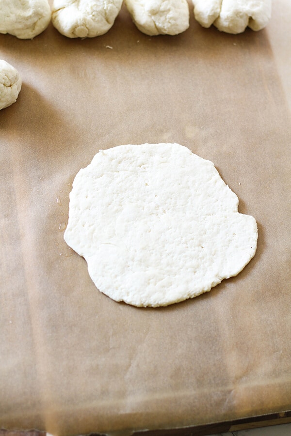 dough flattened out on a board in a circular shape.