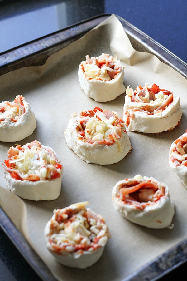 Pizza scrolls on a baking tray ready for the oven.