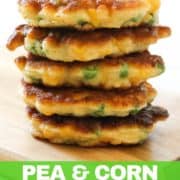 Pea & Sweet Corn Fritters in a stack on a wooden board.