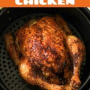 Whole roast chicken sitting in air fryer basket with text overlay "air fryer whole chicken".