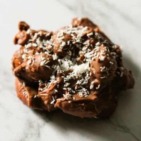 a chocolate covered almond cluster on a marble background