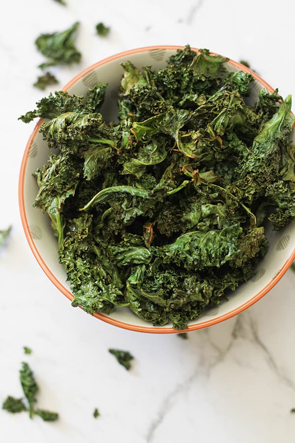 sweet and salty kale chips in a white bowl.