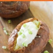 baked potato topped with sour cream and cheese.