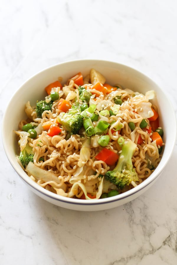 vegetable stir fry with noodles in a white bowl.