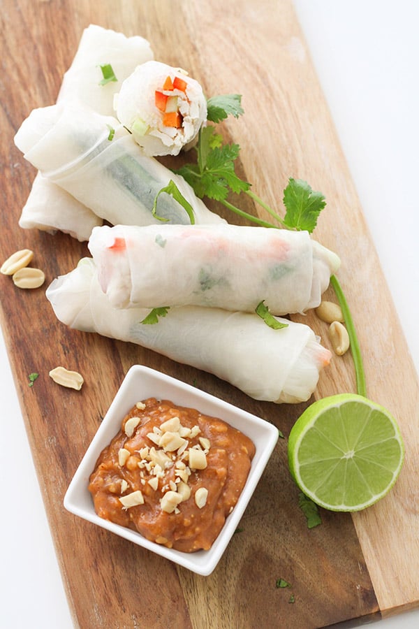 chicken rice paper rolls on a wooden serving board.