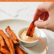 carrot fries being dipped into spicy mayo.