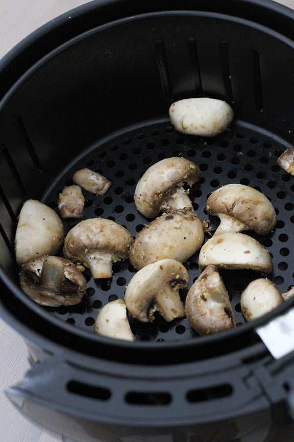 mushrooms in an air fryer basket.