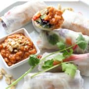 rice paper rolls on a white plate with text overlay "tofu + veggie rice paper rolls".