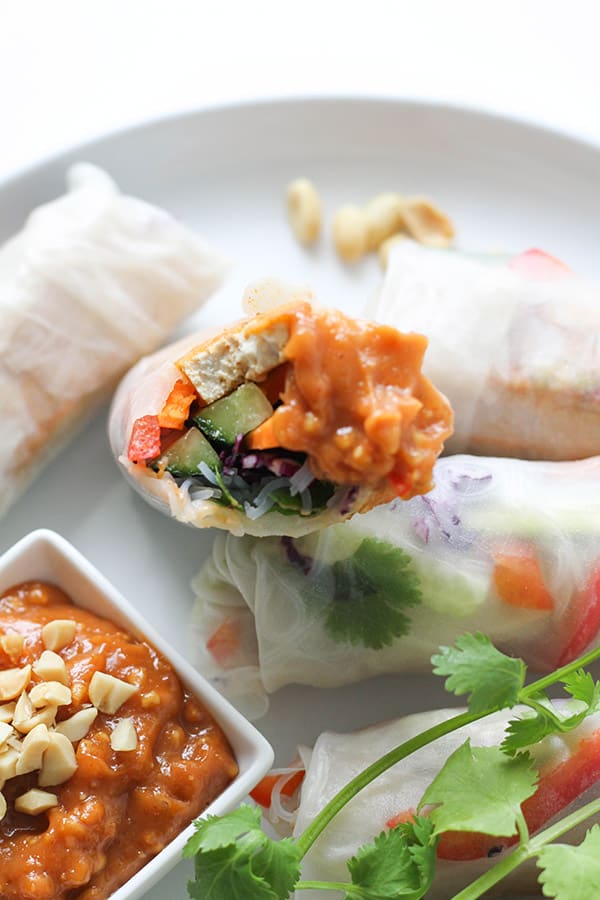 close up of a rice paper roll topped with peanut sauce.