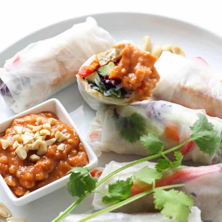 a white plate filled with rice paper rolls.