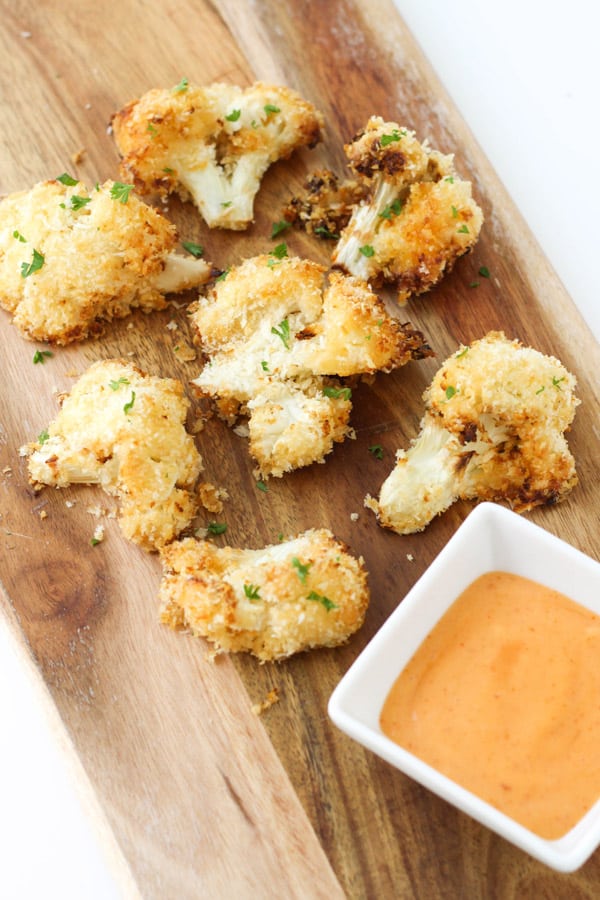 bang bang cauliflower pieces on a wooden serving board.