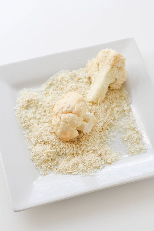 cauliflower pieces on a plate covered in breadcrumbs.