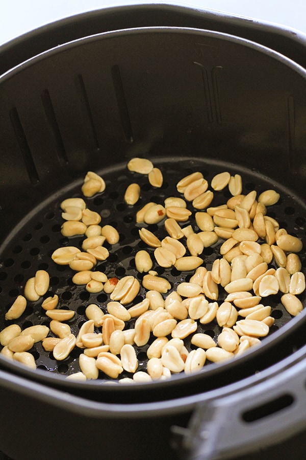 peanuts in an air fryer basket.