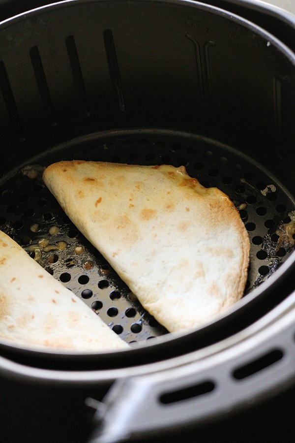 quesadillas in an air fryer basket.