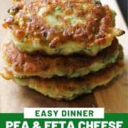 fritters stacked on top of each other on a wooden board with text overlay "pea & feta cheese fritters".