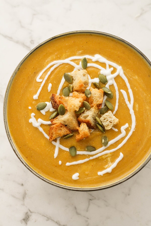 pumpkin soup topped with croutons and pumpkin seeds.