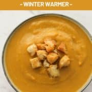 pumpkin soup topped with croutons with text overlay "creamy pumpkin & cauliflower soup".