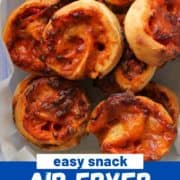 pizza scrolls piled in a plastic container with text overlay "air fryer pizza pinwheels".
