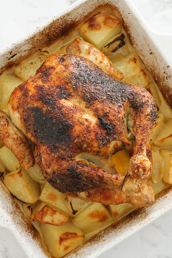 roast chicken and potatoes in a white baking dish.