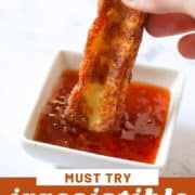 hand dipping a halloumi fry into sweet chilli sauce with text overlay "irresistible halloumi fries".