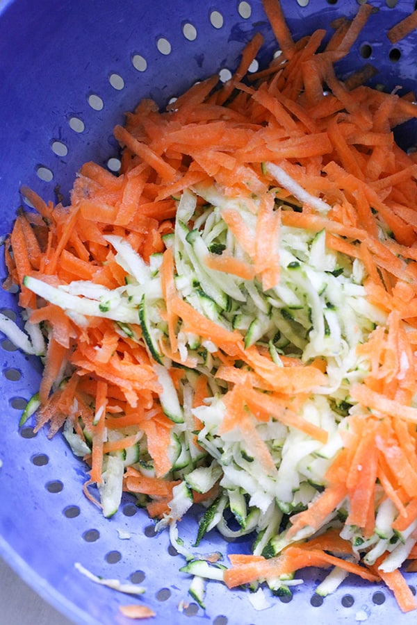 shredded zucchini and carrot in a colander.