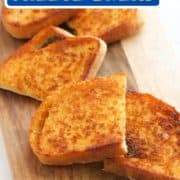slices of cheese toast on a wooden serving board with text overlay "sizzler copycat cheese bread".