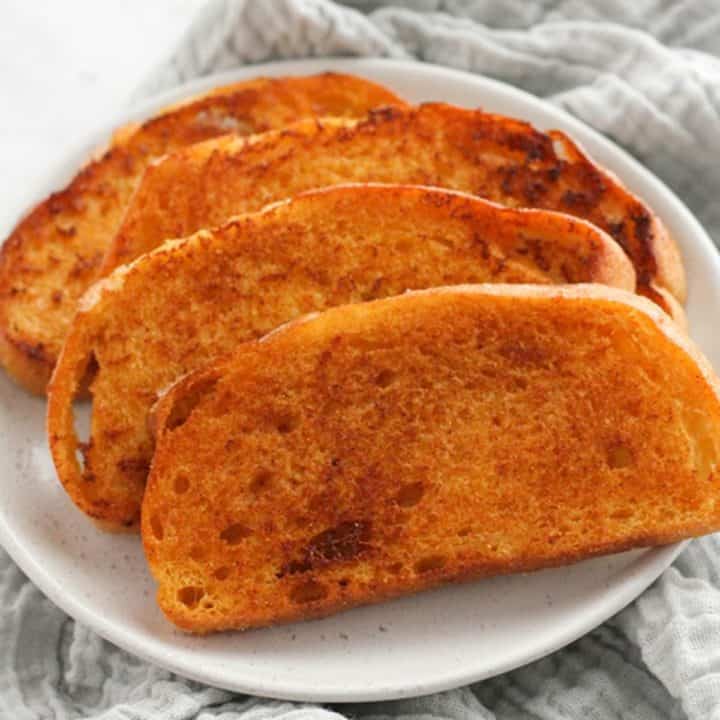 slices of cheese toast on a white plate.