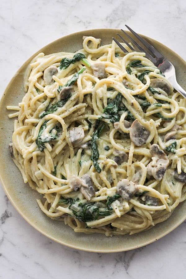 creamy mushroom and spinach pasta on a plate.