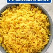 yellow rice in a blue bowl with text overlay "easy oven baked turmeric rice".