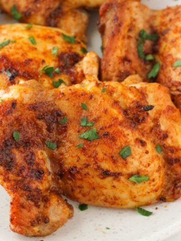 chicken thighs on a plate with parsley.