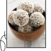 energy balls in a wooden bowl with text overlay "coconut + date balls".